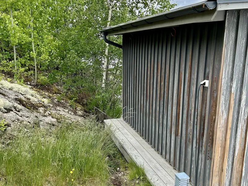 Sjöbodens långsida under arbete, tvättad, skrapad och slipad inför målning